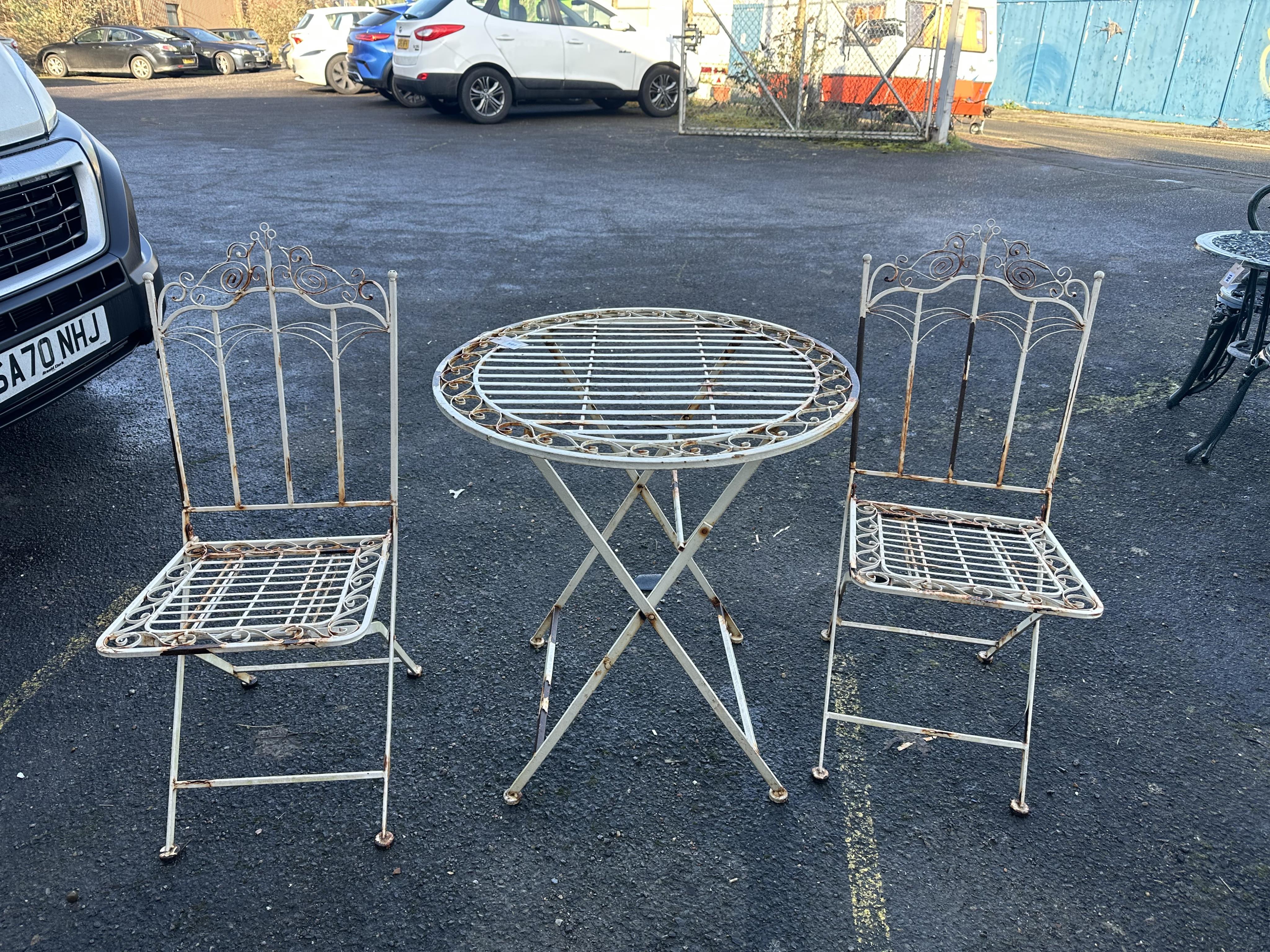 A folding aluminium garden table, diameter 69cm and a pair of folding chairs. Condition - poor